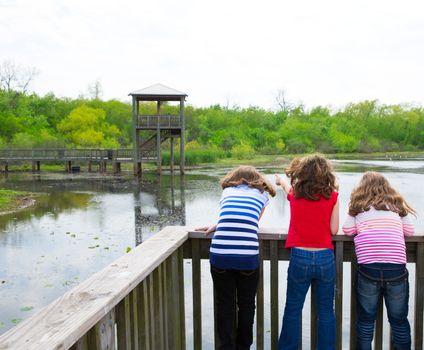 kid children girls looking and pointing at park lake in Texas rear view