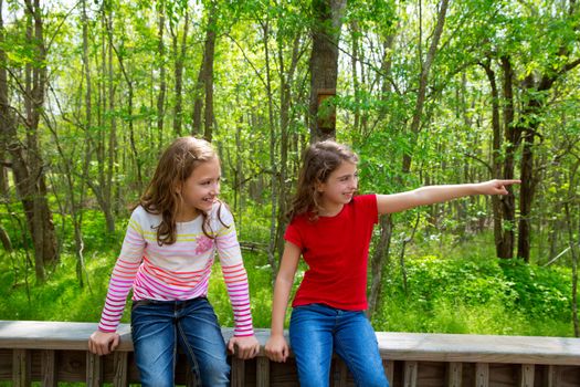 children sister friends playing relaxed pointing finger to jungle park forest outdoor