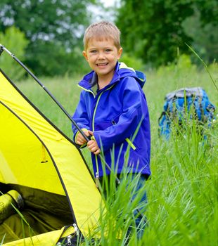 Cute little boy camping with tent outdoor.