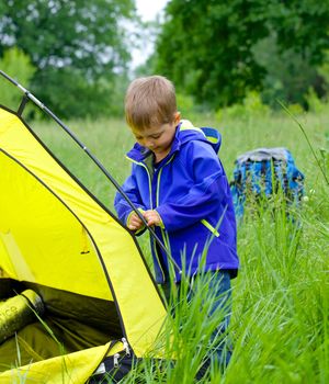Cute little boy camping with tent outdoor.