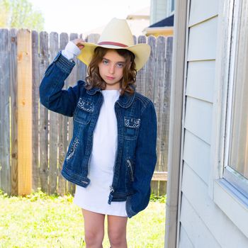 Little kid girl pretending to be a cowboy with father hat and jacket