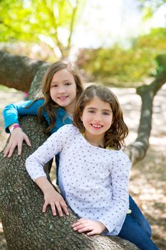 friends sister girls resting on tree trunk nature outdoor