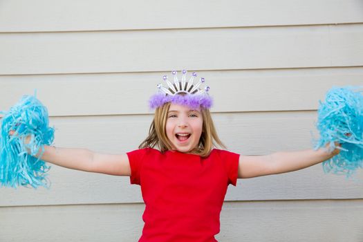 Blond kid girl playing like cheerleading pom poms with princess crown