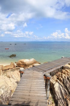 Wooden jetty on tropical beach on island