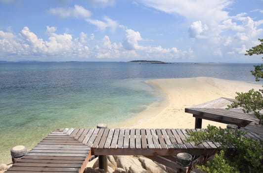 Wooden jetty on tropical beach on island