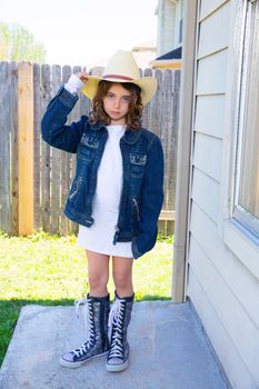 Little kid girl pretending to be a cowboy with father hat and jacket