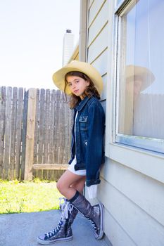 Little kid girl pretending to be a cowboy with father hat and jacket