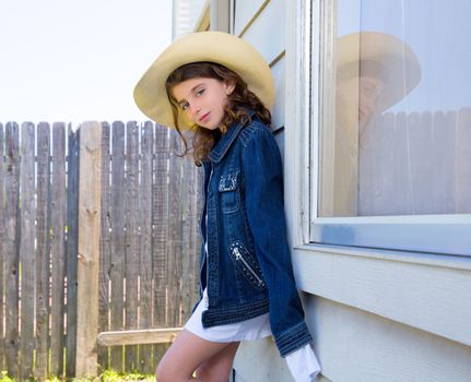 Little kid girl pretending to be a cowboy with father hat and jacket