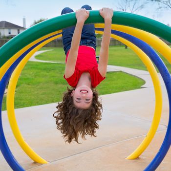 children kid girl upside down on a park playground ring game