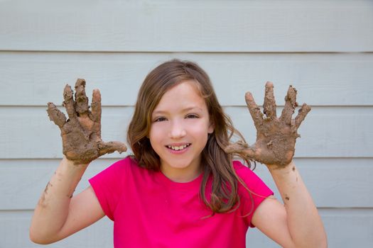 happy kid girl playing with mud with dirty hands smiling portrait