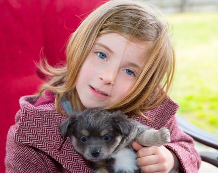 Blond girl hug a gray puppy chihuahua dog with winter coat