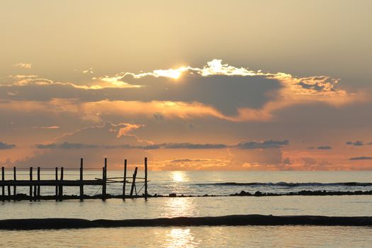 Fiery sunrise over a wooden pier at a tropical resort in the Mayan Riviera, Mexico