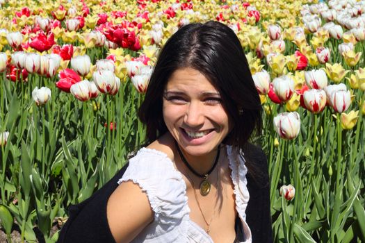 Laughing young woman on spring tulips background