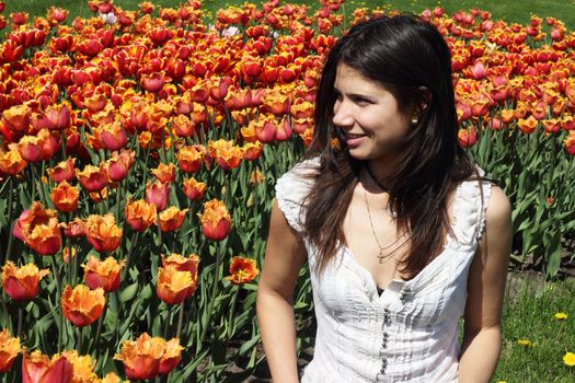 Portrait of a young woman on tulips background