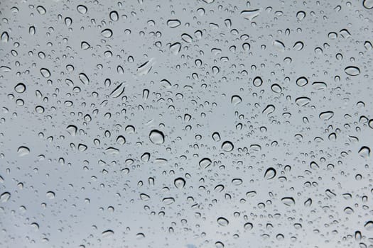 Water drops on transparent gray glass close up