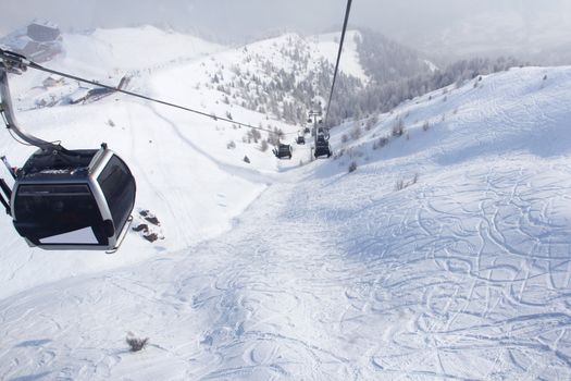 Chairlift in mountains and panoramic view on winter alps 