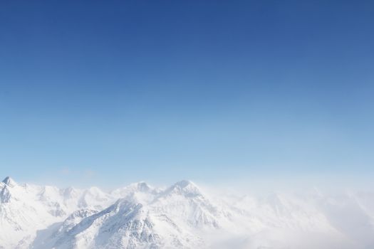 Mountain peaks of winter alps under blue sky