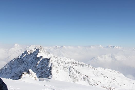 Mountain peaks of winter alps under blue sky