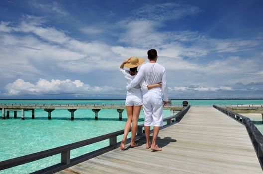 Couple on a tropical beach jetty at Maldives