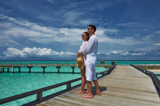 Couple on a tropical beach jetty at Maldives