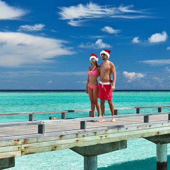 Couple on a tropical beach jetty at Maldives