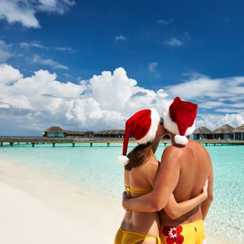 Couple in santa's hat on a tropical beach at Maldives