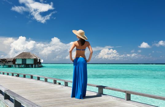 Woman on a tropical beach jetty at Maldives