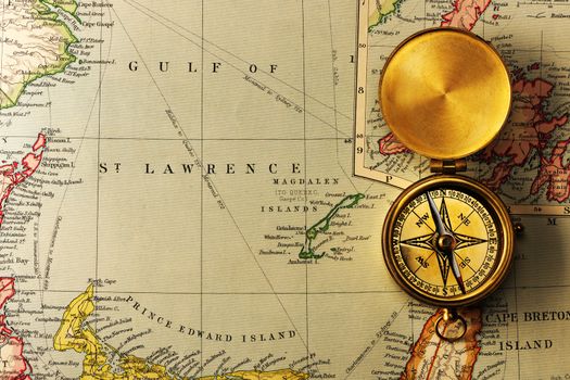 Antique brass compass over old XIX century map
