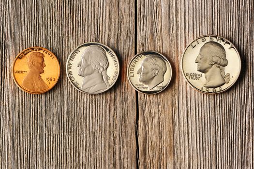 Four US cent coins over wooden background