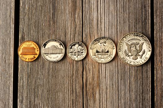 Five US cent coins over wooden background