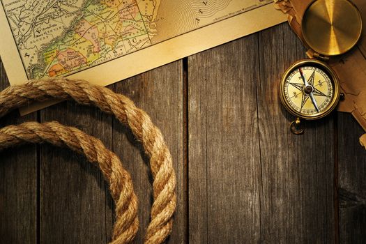 Antique brass compass and rope over old map