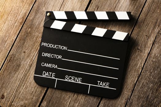 Movie production clapper board over wooden background