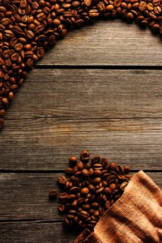 Coffee beans and bag over wooden background