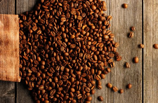 Coffee beans and bag over wooden background