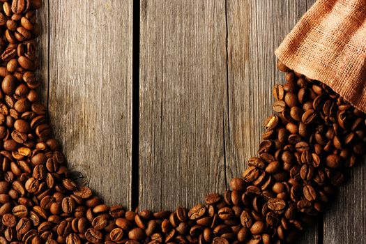 Coffee beans and bag over wooden background