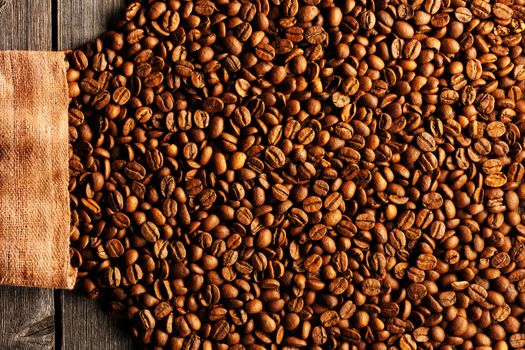 Coffee beans and bag over wooden background