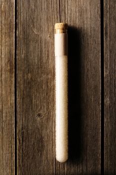 Sea salt in beaker on wooden background