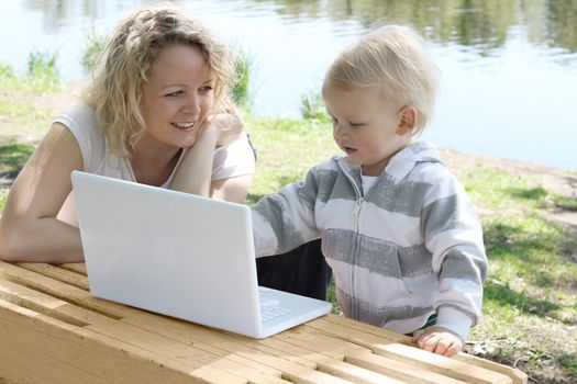 young mother and child with laptop outdoor