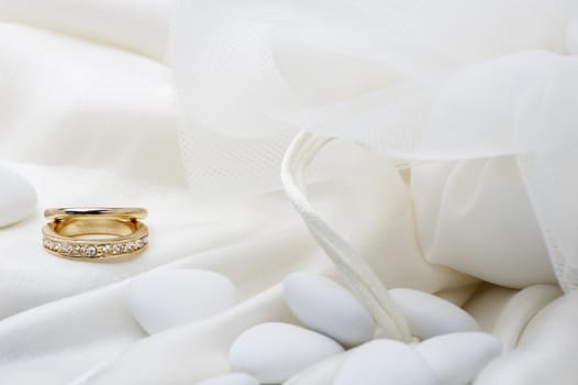 a roses and wedding rings on white background