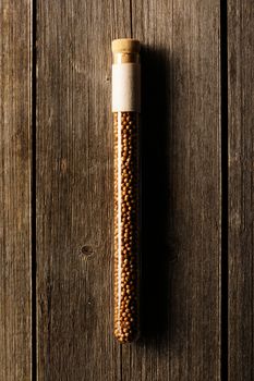 Coriander in beaker on wooden background