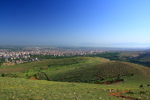 village between hills on spring day with blue sky