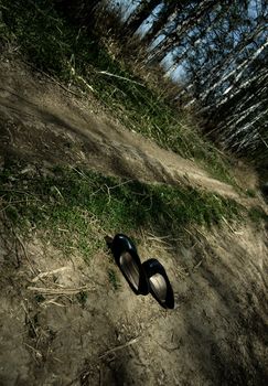 Photo of the lost old shoes on the forest pathway