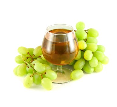 Grape juice in wine glass surrounded with grapes isolated on white