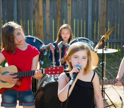 Blond kid singer girl singing playing live band in backyard concert with friends