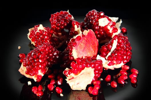 fresh ripe pomegranate pieces on black background