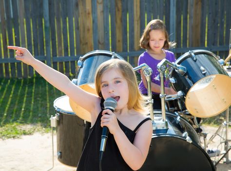 Blond kid singer girl singing playing live band in backyard concert with friends