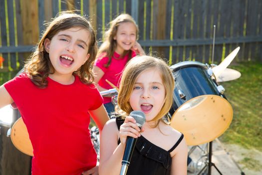 Blond kid singer girl singing playing live band in backyard concert with friends