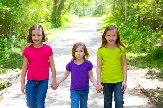 Friends and sister girls walking outdoor in forest track excursion