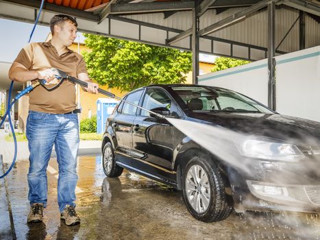 An image of a man washing his car