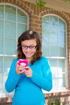 Teenager girl with glasses playing with pink smartphone smiling